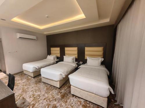 una habitación de hotel con 3 camas en una habitación en فندق دان البلاتيني en Medina