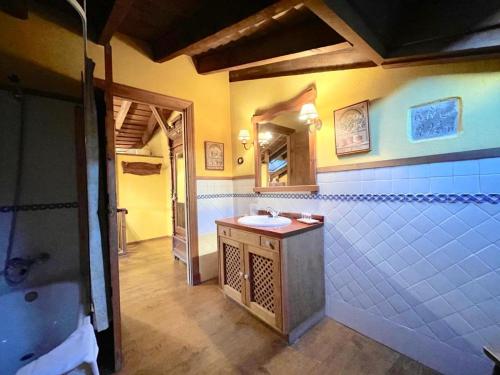 een badkamer met een wastafel en een spiegel bij El Encanto De Miraflores in Miraflores de la Sierra