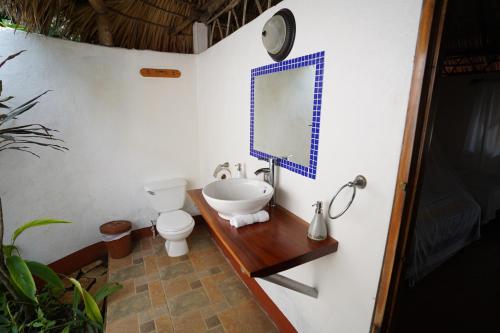 a bathroom with a sink and a toilet and a mirror at Hotel Mariposa in León
