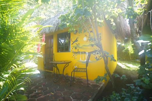 a yellow house with a table and chairs in a garden at Hotel Mariposa in León