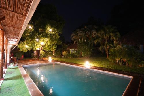a swimming pool in a yard at night at Hotel Mariposa in León