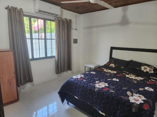 - une chambre avec un lit doté d'une couette bleue et d'une fenêtre dans l'établissement Casa amoblada en Villarrica - Py, à Villarrica