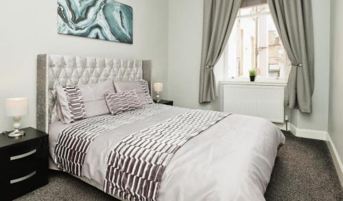 a bedroom with a large bed and a window at Modern Glasgow City Centre Apartment in Glasgow