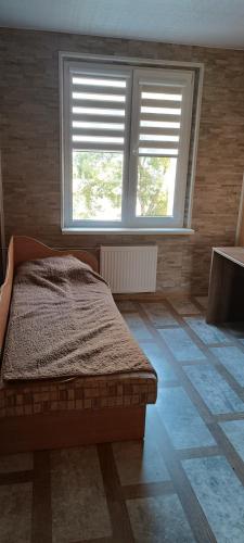um quarto com uma cama e duas janelas em Trumpalaikė nuoma em Elektrėnai