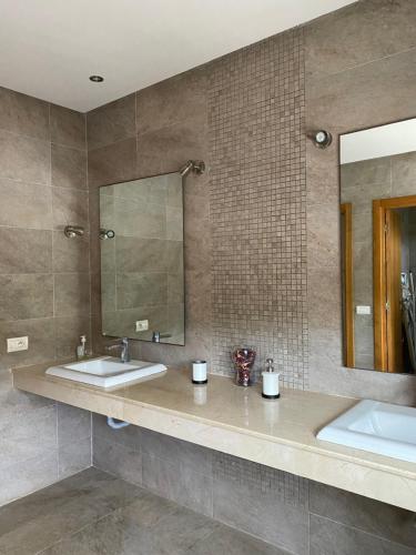 ein Badezimmer mit 2 Waschbecken und einem Spiegel in der Unterkunft Villa de luxe centrale Harhoura in El Harhoura