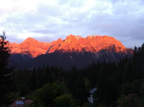 a mountain range with the sun shining on it at Bäckeralm© - B&B 16 + in Mittenwald