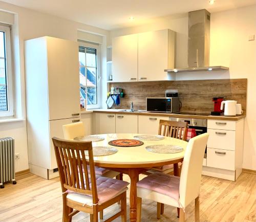 uma cozinha com uma mesa e cadeiras numa cozinha em Heimat - Apartment in der Altstadt Fulda l 47 qm l Netflix l WLAN l Wohnzimmer l Schlafzimmer l Küche l Bad em Fulda