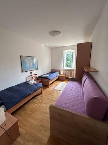 a living room with two beds and a couch at CA' EDDA APPARTAMENTO ANNA in Brentonico