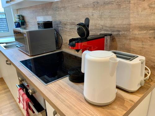 uma cozinha com um balcão com uma torradeira e um micro-ondas em Heimat - Apartment in der Altstadt Fulda l 47 qm l Netflix l WLAN l Wohnzimmer l Schlafzimmer l Küche l Bad em Fulda