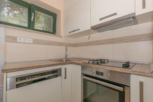 a kitchen with white cabinets and a counter top at Holiday home Masha in Bogomolje