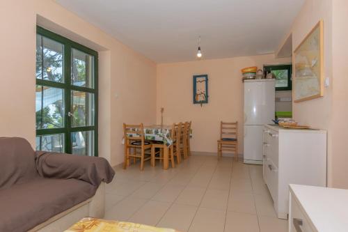 a kitchen and living room with a refrigerator and a table at Holiday home Masha in Bogomolje