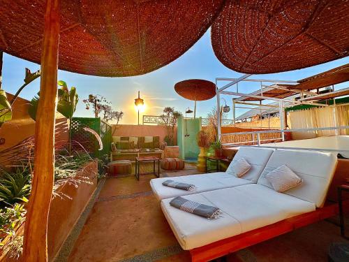 a white couch sitting on a patio under an umbrella at Riad 11 Zitoune in Marrakech