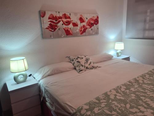 a bedroom with a bed with two night stands and two lamps at Benidorm in Benidorm