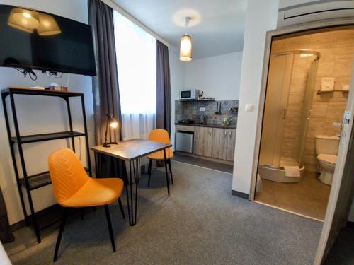 ルブリンにあるPokoje z aneksami Orla 6のテーブルと椅子、バスルームが備わる客室です。