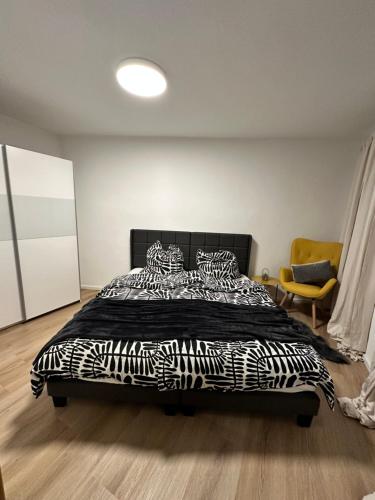 a bedroom with a bed with a black and white comforter at City Apartment in Sankt Ingbert