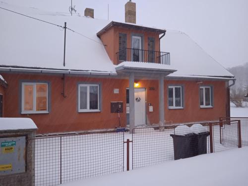 a house with a fence in the snow at Chata Elča in Lipova Lazne