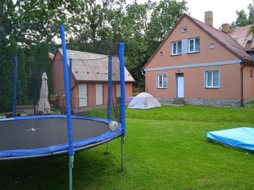 un patio con una cama elástica y una casa en Chata Elča, en Lipová-lázně