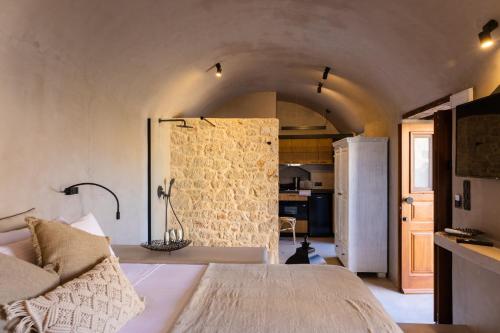 a bedroom with a bed and a kitchen with a refrigerator at EliteDIMension Chalki in Halki