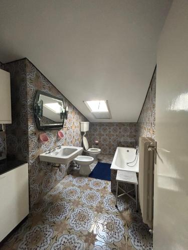 a bathroom with two sinks and a toilet and a tv at CA' EDDA APPARTAMENTO GIULIA in Brentonico
