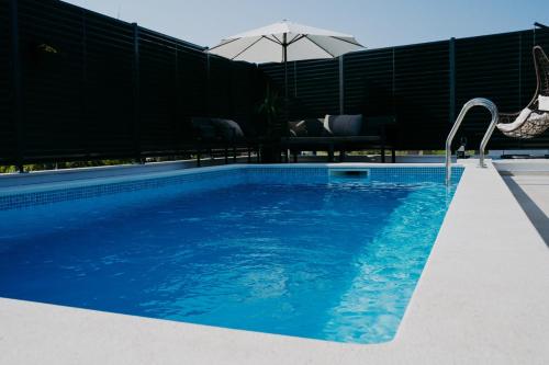 una piscina de agua azul y una sombrilla en AMI en Solin