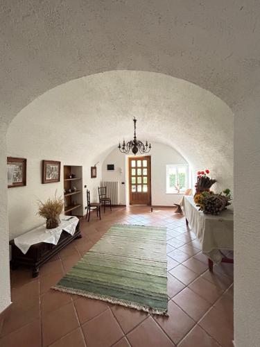 a large living room with a chandelier and a table at CA' EDDA APPARTAMENTO GIULIA in Brentonico