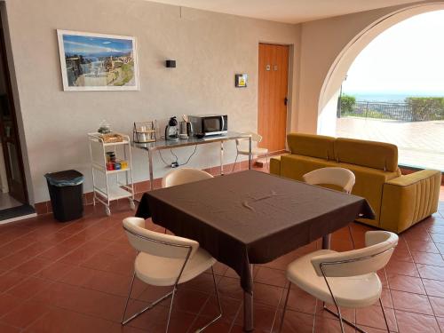 a living room with a table and chairs and a couch at Villa Leucatia in Sant’Agata Li Battiati 