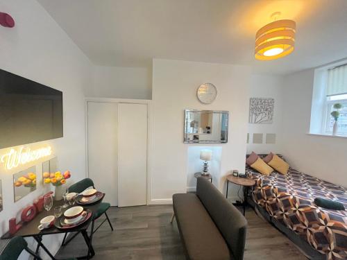 een woonkamer met een groot bed en een bank bij Studio flat in Shipley Central in Shipley