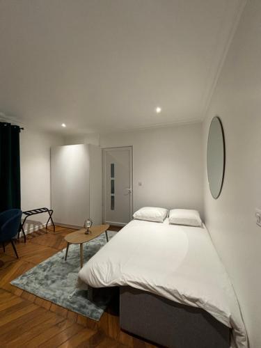 a bedroom with a large bed and a table at Studio d’Exception à 2mn Gare RER C Choisy-le-Roi in Choisy-le-Roi