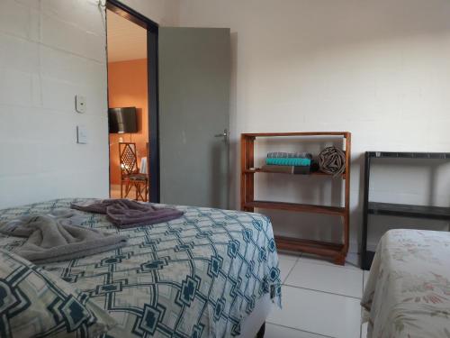 um quarto com uma cama com um cobertor em Pousada Alecrim em Aquiraz