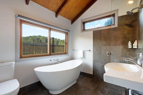 a bathroom with a tub and a sink and a window at Tanja Lagoon Camp in Tanja