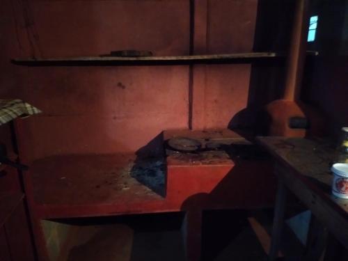 a stove in a room with a table and a shelf at CAMPING SÃO BENEDITO in São Roque de Minas