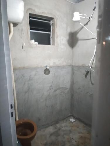 a small bathroom with a toilet and a window at CAMPING SÃO BENEDITO in São Roque de Minas