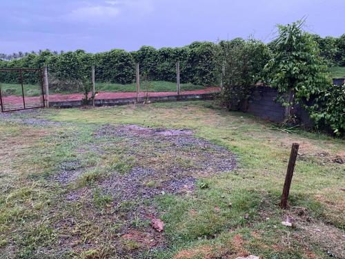 a yard with a fence and a grass field at CAMPING SÃO BENEDITO in São Roque de Minas