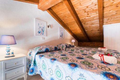 a bedroom with a bed and a wooden ceiling at Residence Fior di Sulcis in Calasetta