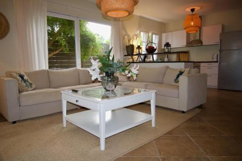 a living room with a vase of flowers on a coffee table at Luxury appt for 6: mesmerizing Spanish water view in Jan Thiel