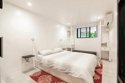 a white bedroom with a bed and a red rug at Central Location Brooklyn Stay at Rem-Casa in Brooklyn