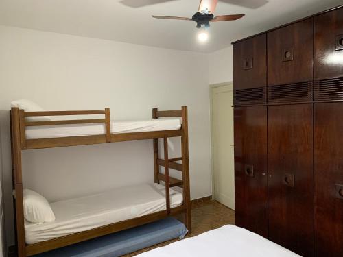 a bedroom with bunk beds and a ceiling fan at Apartamento Vista Mar in Peruíbe