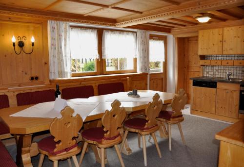 eine Küche mit einem großen Holztisch und Stühlen in der Unterkunft Saffretta Ferienwohnungen in Ischgl