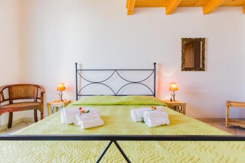 a bedroom with a large bed with two pillows on it at Residence Fior di Sulcis in Calasetta