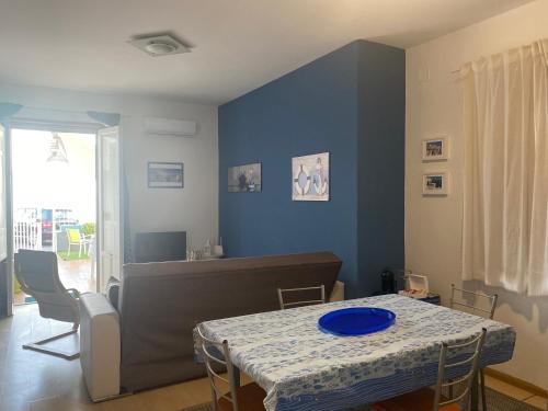 une salle à manger avec une table et un mur bleu dans l'établissement Casa Galatea, à Aci Trezza