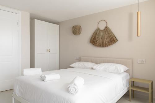 a white bedroom with a white bed with towels on it at Diamond in the Desert- for families in Eilat