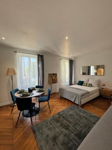 Un dormitorio con una cama y una mesa y sillas. en Le Charmant - Parking Gratuit, Wifi, RER C Choisy-le-Roi, en Choisy-le-Roi