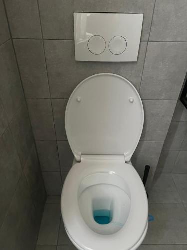 een wit toilet in een badkamer met deksel omhoog bij Bkenkember Aprt in Antwerpen