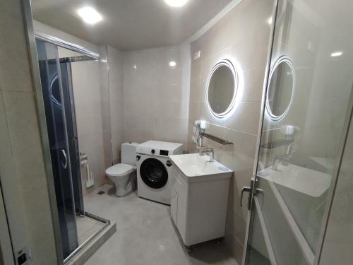 a bathroom with a washing machine next to a toilet at House number 1 in kutaisi in Kutaisi