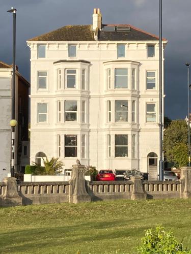a white house with a fence in front of it at Southsea, Portsmouth - Two Bedroom Apartment - Newly Refurbished Throughout - Treetop Sea Views in Portsmouth