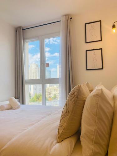 Schlafzimmer mit einem Bett und einem großen Fenster in der Unterkunft Appartement Privé La Défense Paris in Courbevoie
