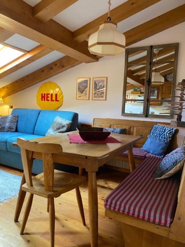 - un salon avec une table en bois et un canapé bleu dans l'établissement Mansardina Mery Cortina, à Cojana