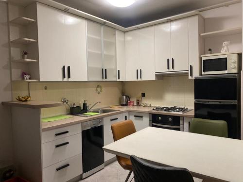 een keuken met witte kasten en een tafel met stoelen bij Affordable Apartments 8 in Zagreb
