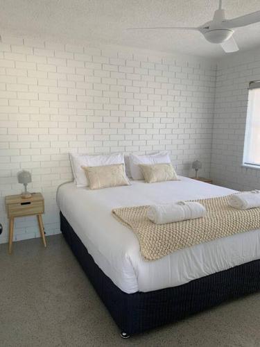 a large bed in a room with a brick wall at Bribie Get away in Bongaree