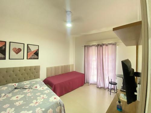 a bedroom with a bed and a tv in it at Apto Santos Gonzaga in Santos